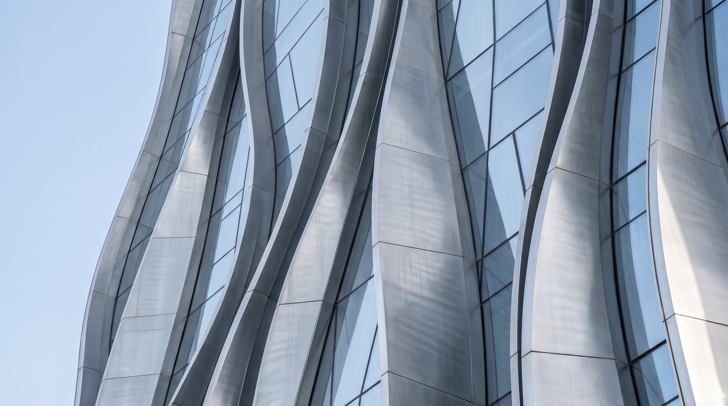 Undulating silver façade against a blue sky