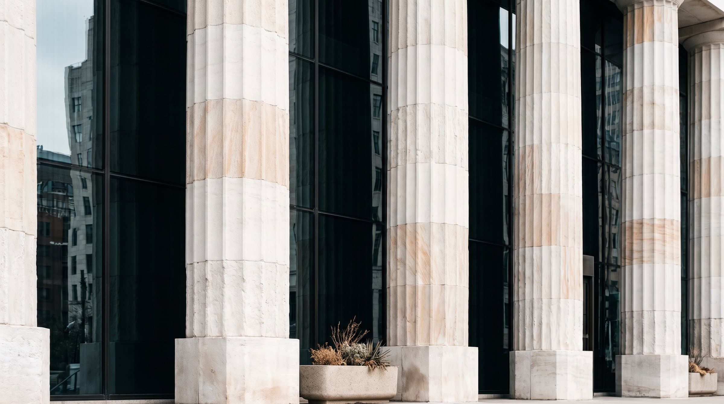 Stone colonnade in front of a glass façade