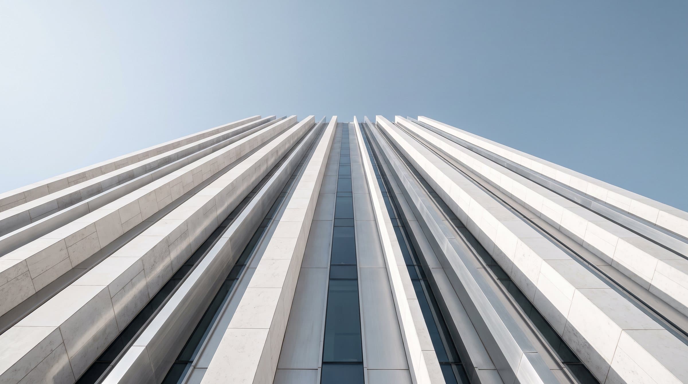 Looking up a white tower against a clear sky