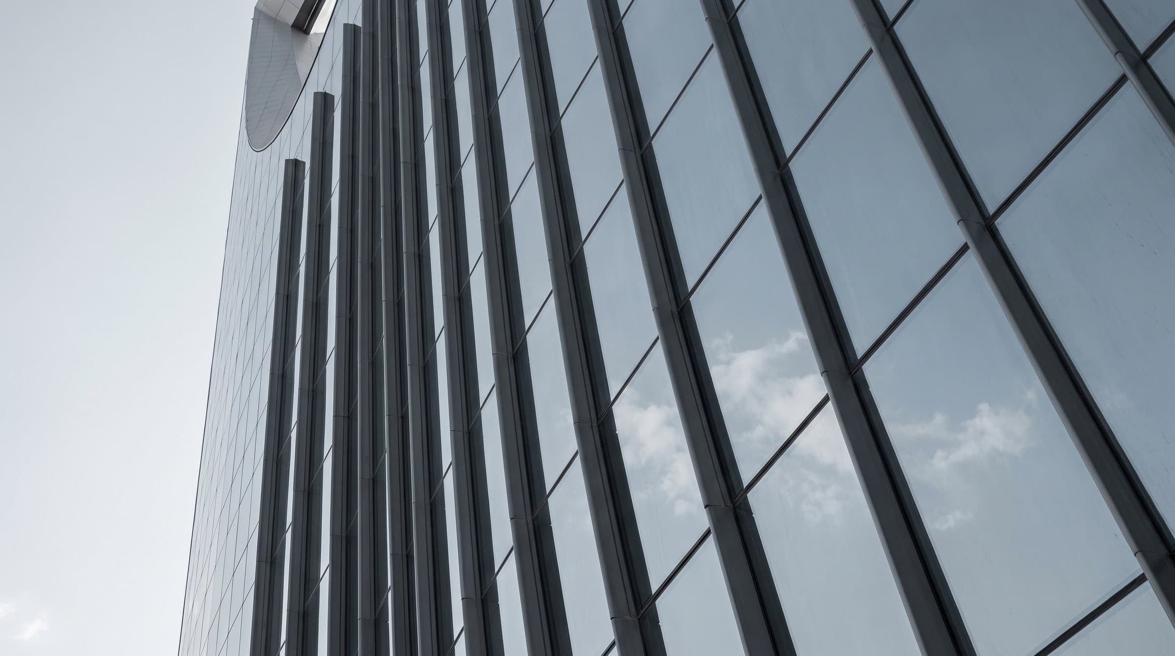 Glass tower reflecting a cloudy sky